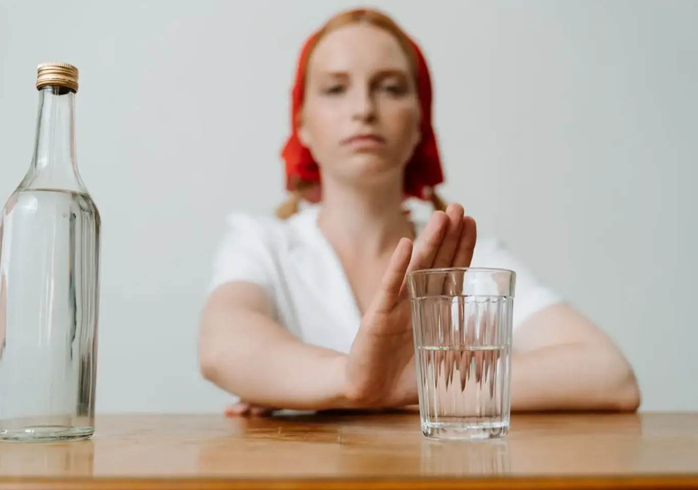 Leczenie alkoholizmu Ostrołęka: kobieta odsuwa butelkę i sięga po wodę