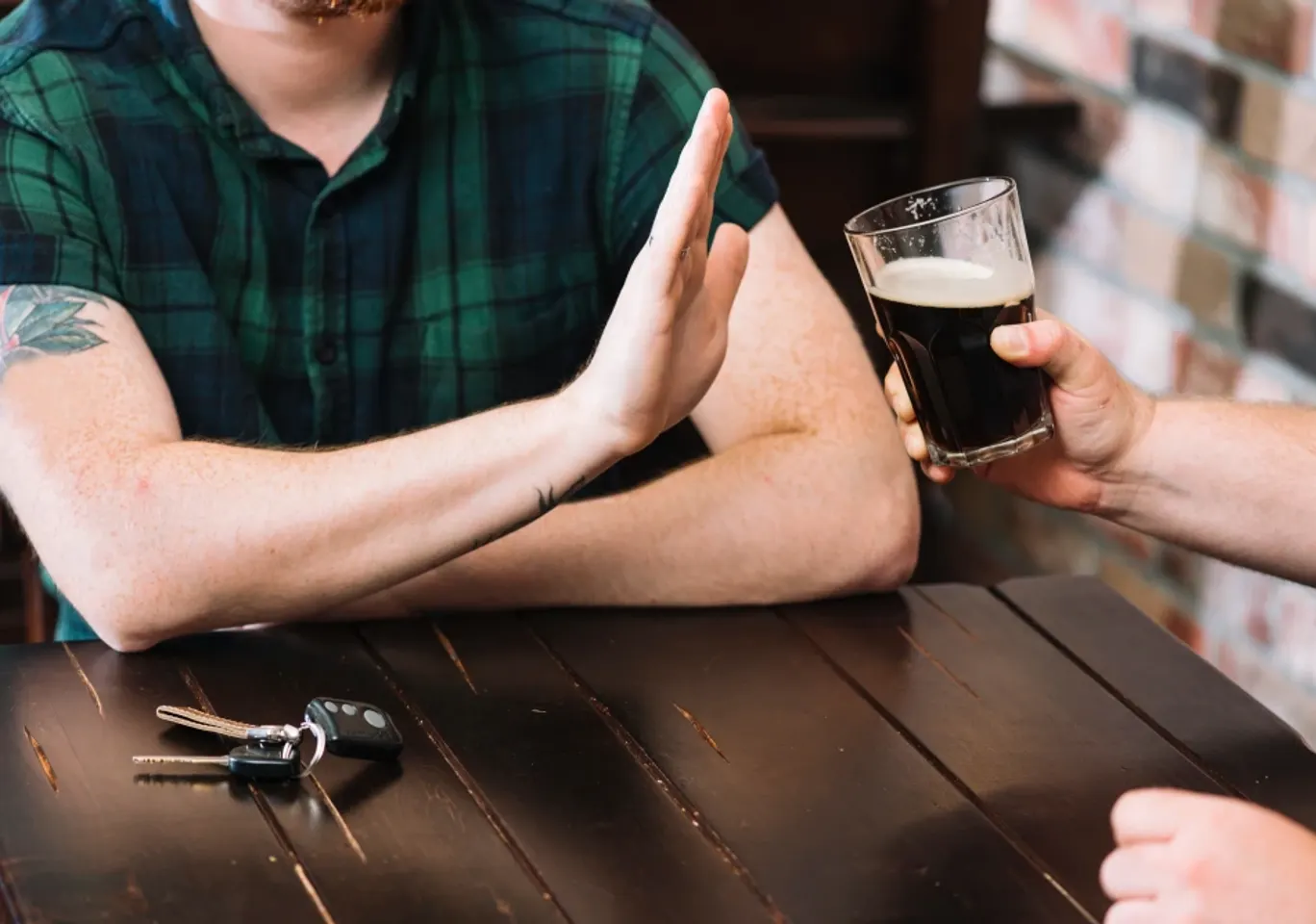 Leczenie alkoholizmu Ostrołęka: dłoń odmawiająca kufla piwa przy stole